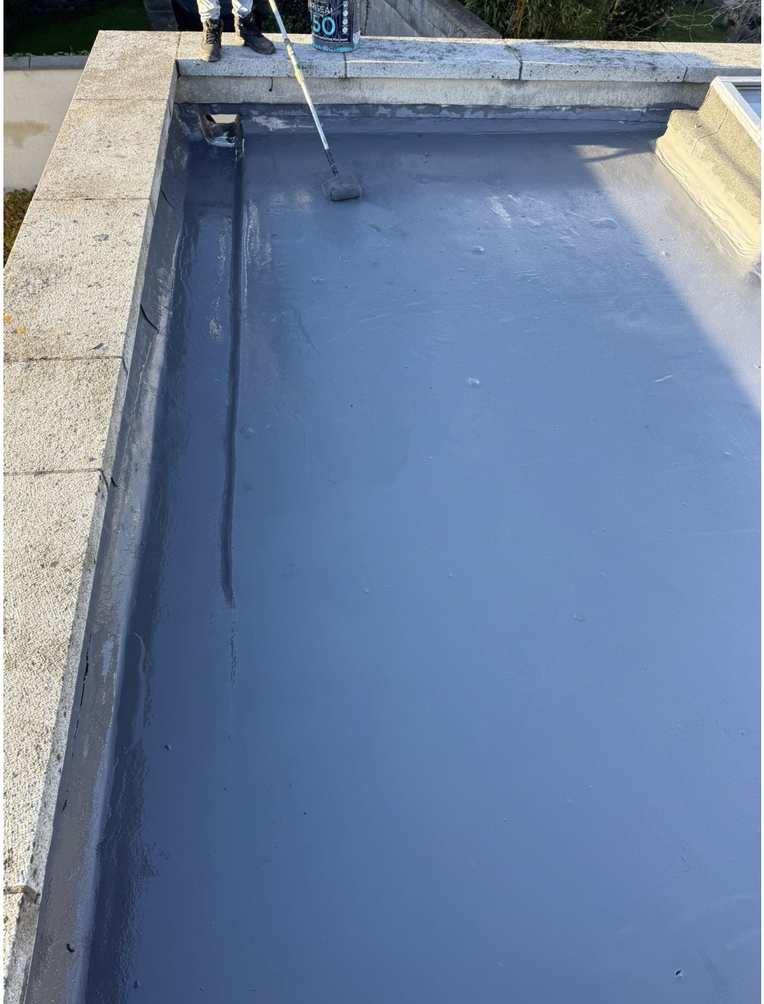 Liquid waterproof coating being rolled onto a flat roof in Dublin