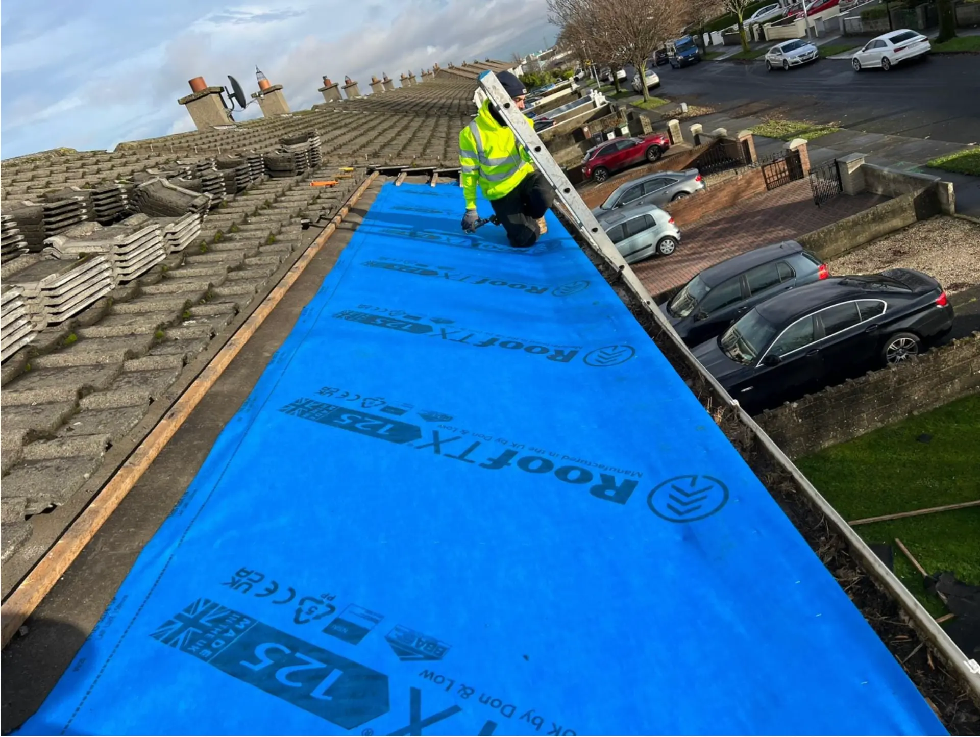 Roofer laying breather membrane across a Dublin roof