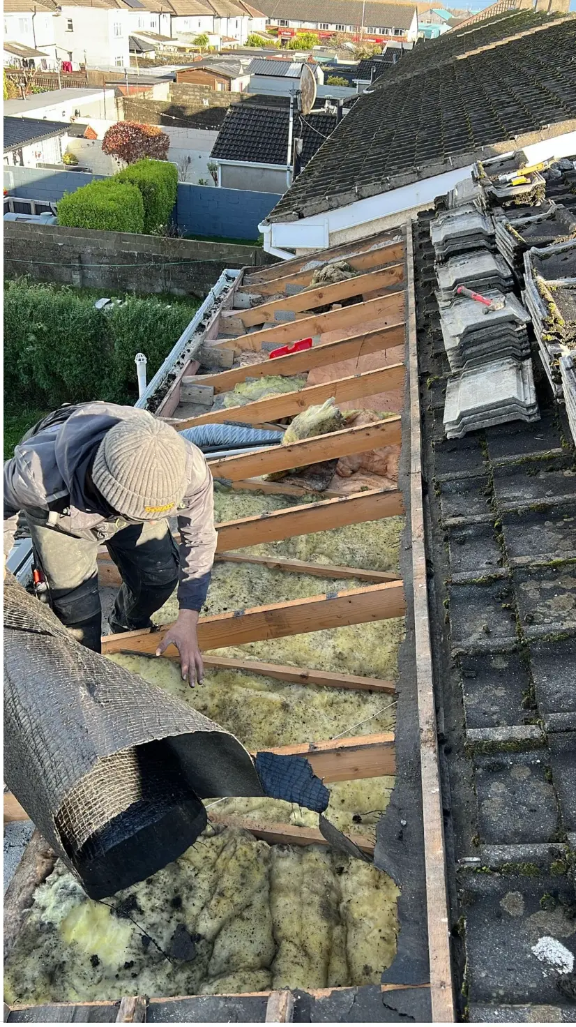 Roofer stripping old felt and tiles from a Dublin roof